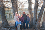 Family portrait of 5 standing in front of trees